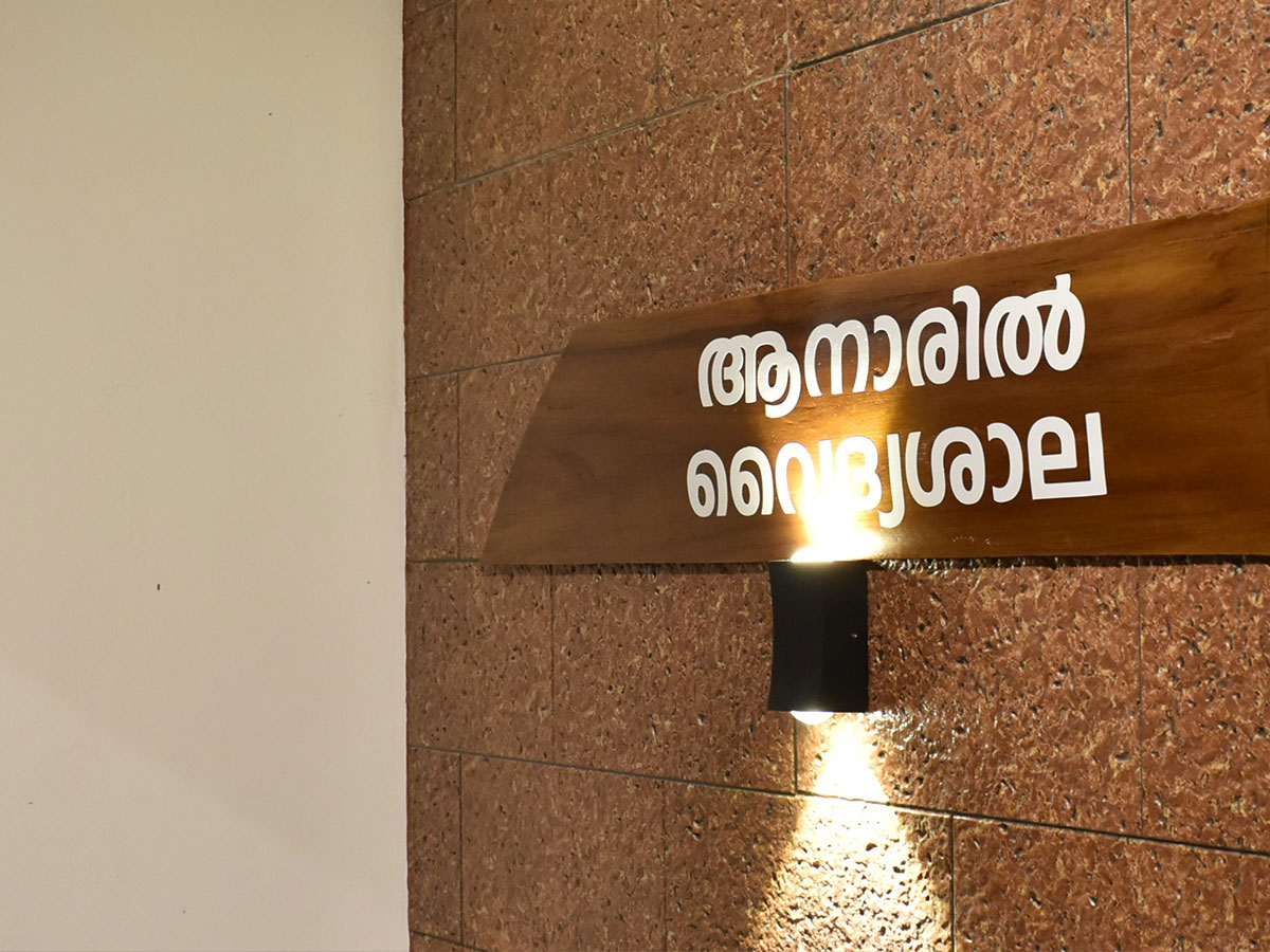 The carved wooden nameboard reading Anaril Vaidyasala in Malayalam